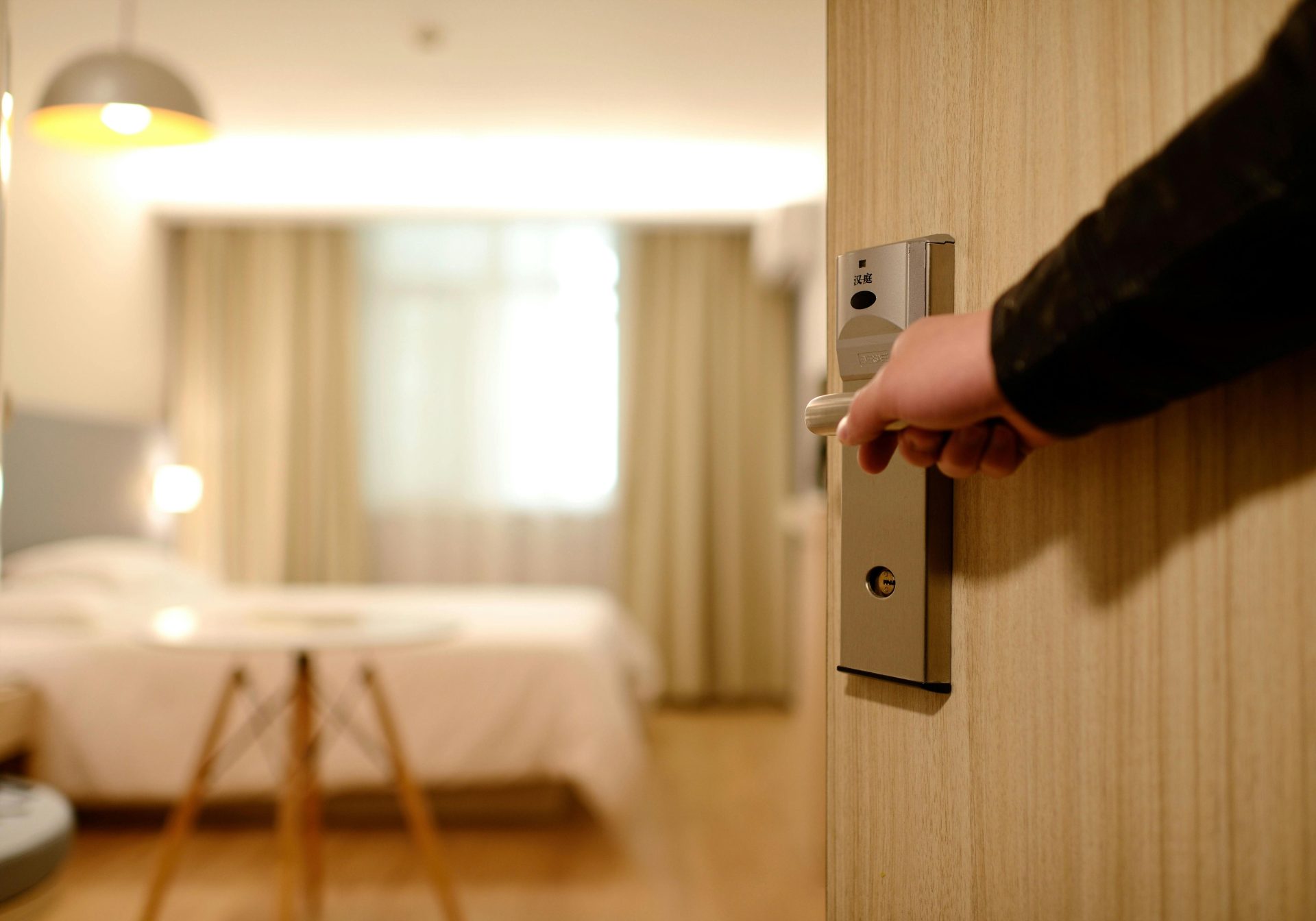 La entrada a la habitación del hotel, con una iluminación tenue, da la bienvenida a los huéspedes con un ambiente lujoso y confortable.